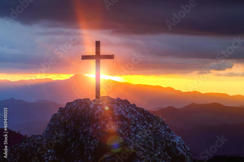 Photo Silhouettes of crucifix symbol on top mountain with a bright sunbeam on the colorful sky background