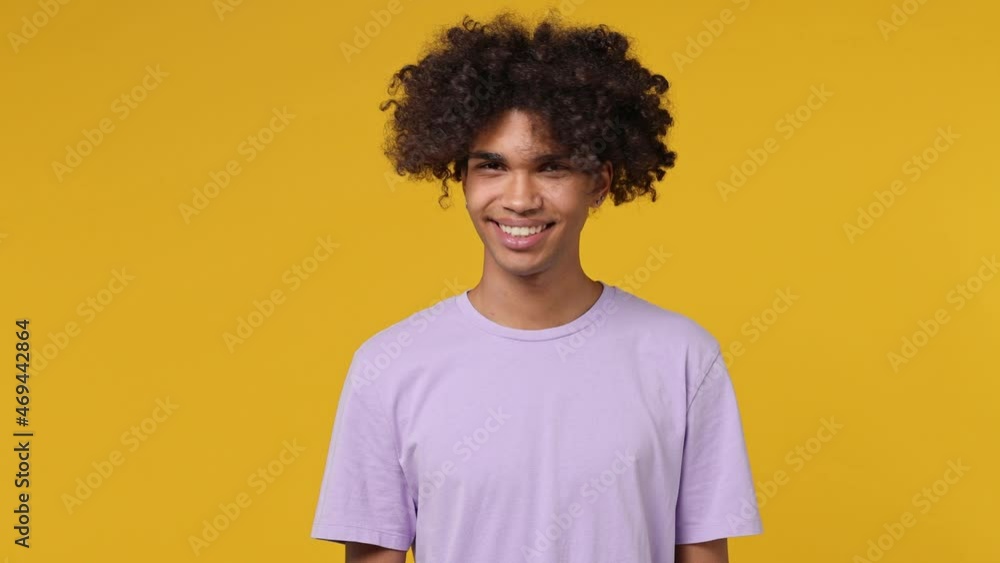 Vivid happy young curly african american man 20s years white t-shirt look camera pointing fingers himself ask say who me no thanks i do not need it isolated on plain yellow background studio portrait Vivid happy young curly african american man 20s years white t-shirt look camera pointing fingers himself ask say who me no thanks i do not need it isolated on plain yellow background studio portrait