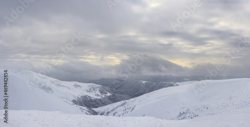 Panoramic view to snow-covered mountain slopes at sunset. Winter landscape. Carpathian Mountains. © Oleksiy