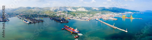 Industrial seaport Novorossiysk , top view. Port cranes and cargo ships and barges. Loading and shipment of cargo at the port. View of the sea cargo port with a bird's eye view. photo