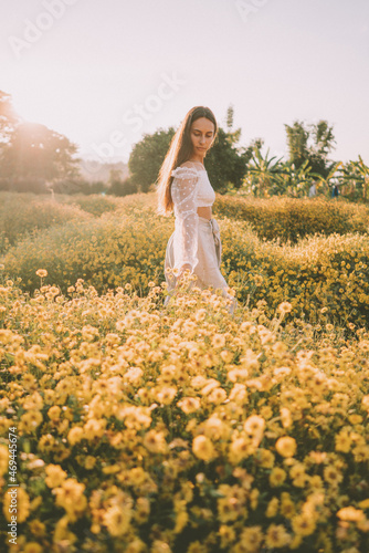 Young attractive woman having fun in yellow flower field
