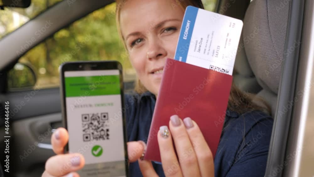 Portrait of a girl with a phone with a QR code about vaccination on the screen and a passport with a plane ticket in the car. Health passport. Portrait of a girl with a phone with a QR code about vaccination on the screen and a passport with a plane ticket in the car. Health passport.