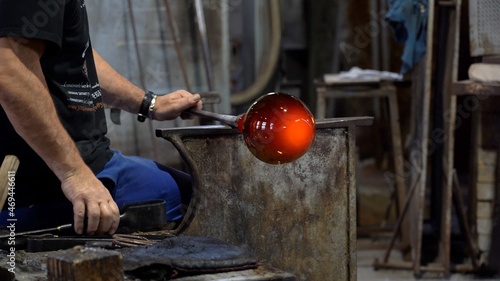 Murano, Venice,Italy November 2021 : Making famous Venetian glass in Murano, glass making - actual process inside the factory in Venice - 
cooling the glowing glass ball