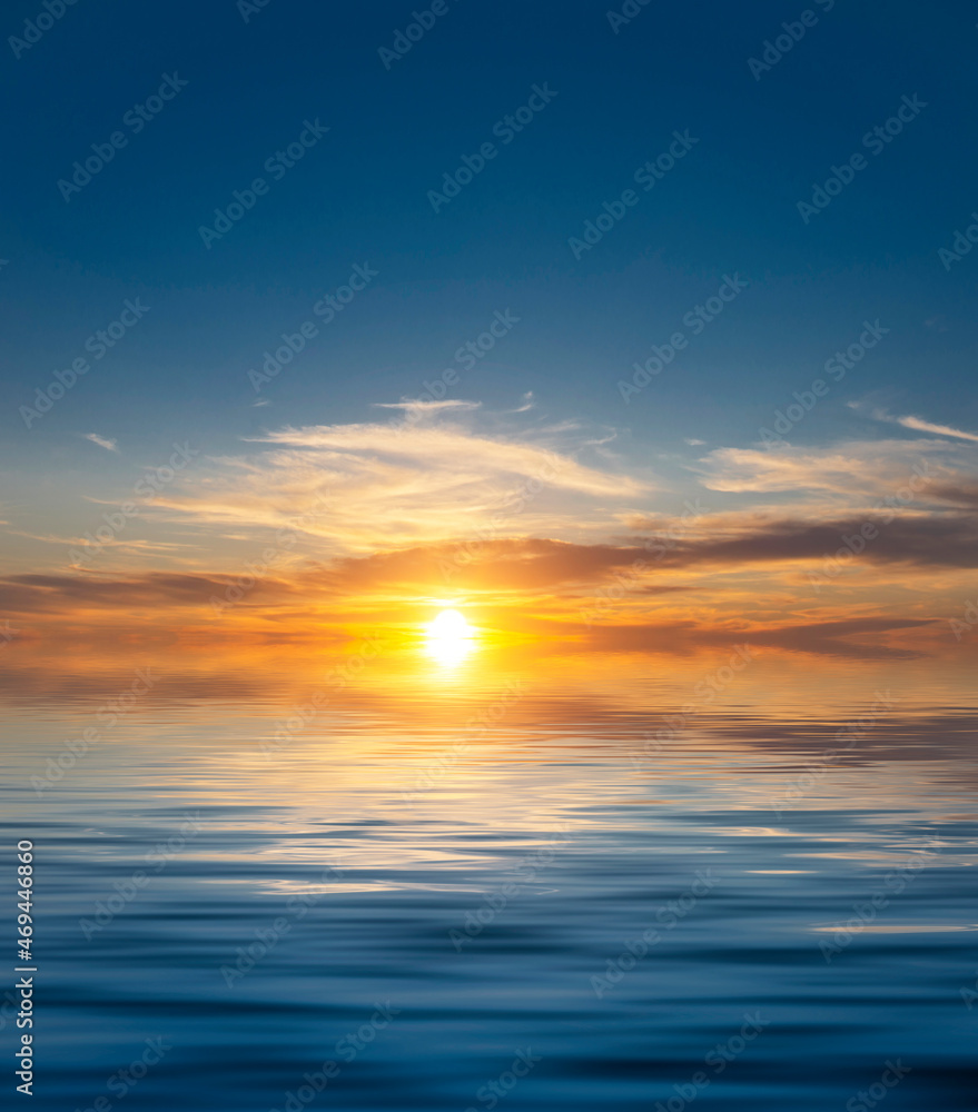Amazing dawn in a clear sky with a bright sun in the clouds above the sea waves.