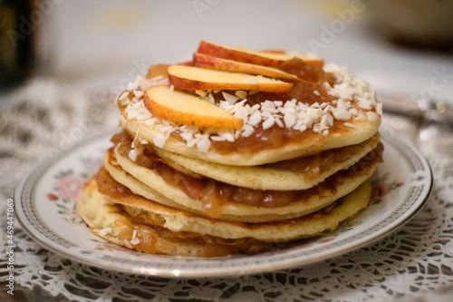 Stack of American apple  pancakes with jam, nuts and apples