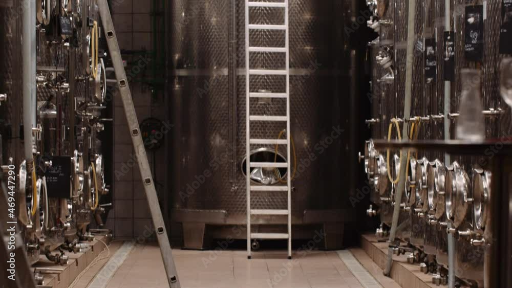 Tilt-up shot reveals stainless steel wine tanks at a cellar Tilt-up shot reveals stainless steel wine tanks at a cellar