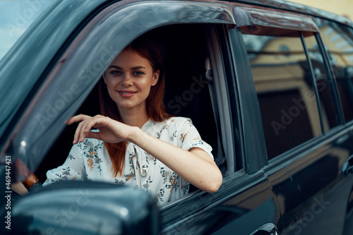 cheerful woman driving a car looks out of the window