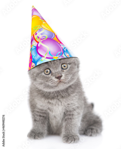 Fototapeta Naklejka Na Ścianę i Meble -  Funny kitten wearing party cap sits in front view and looks at camera. isolated on white background