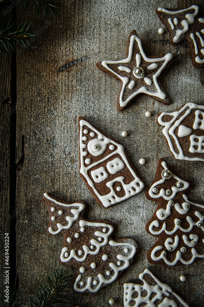 Homemade Christmas gingerbread village with Christmas trees, houses and men sprinkled with icing sugar on rustic wooden table. Homemade Christmas gingerbread village with Christmas trees, houses and men sprinkled with icing sugar on rustic wooden table.