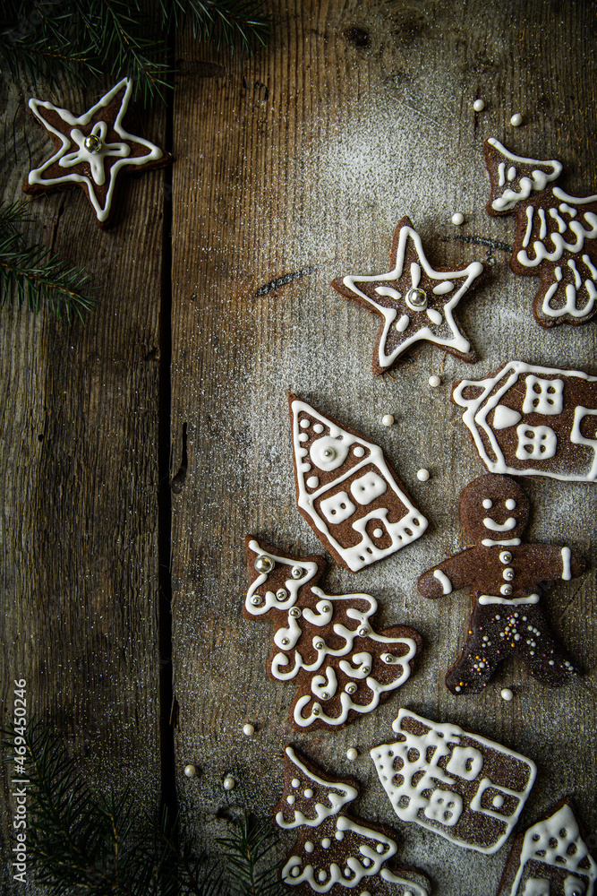 Homemade Christmas gingerbread village with Christmas trees, houses and men sprinkled with icing sugar on rustic wooden table. Homemade Christmas gingerbread village with Christmas trees, houses and men sprinkled with icing sugar on rustic wooden table.