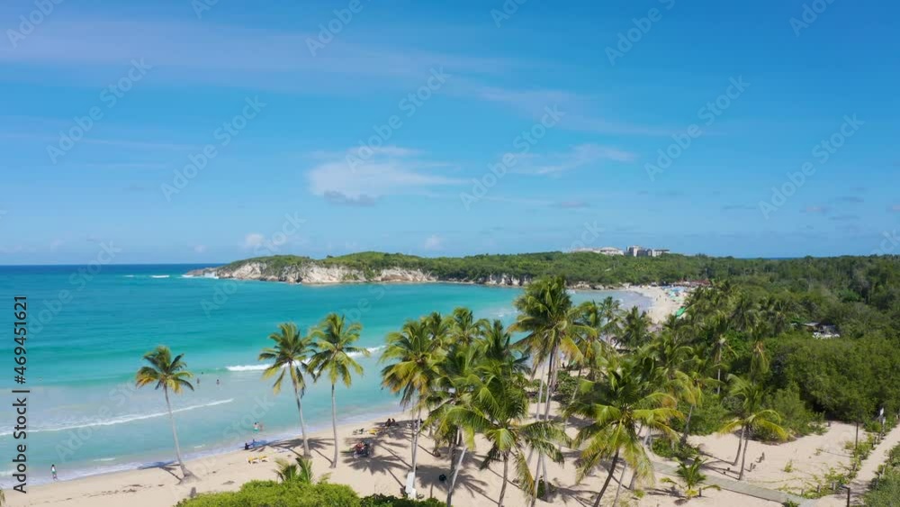 Sunny palm beach Macau in the Dominican Republic. Turquoise ocean waves under bright blue sky. Green tropical stripes in the Caribbean. Beautiful summer seascape. Sunny palm beach Macau in the Dominican Republic. Turquoise ocean waves under bright blue sky. Green tropical stripes in the Caribbean. Beautiful summer seascape.