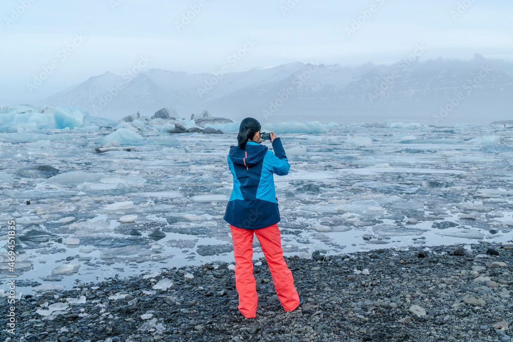 woman taking photo of ice field in Iceland