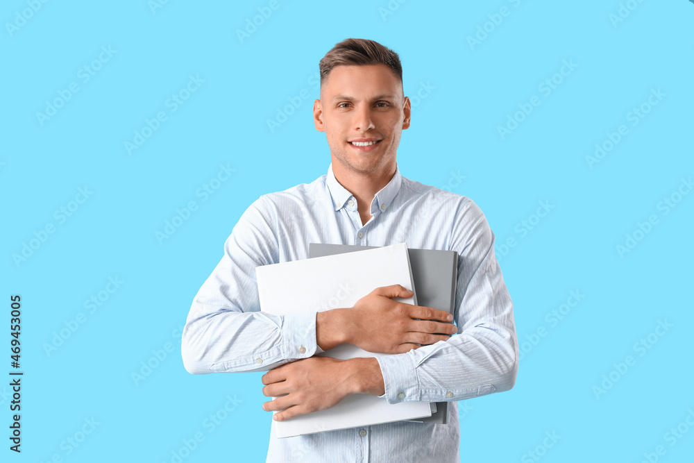 Young man with folders on color background Young man with folders on color background