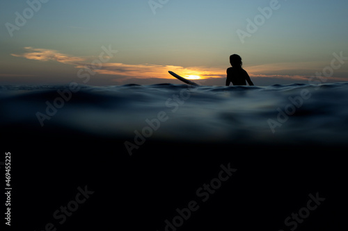 beautiful girl with a surfboard at sunset.