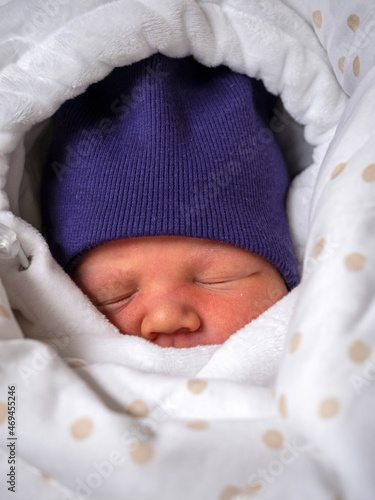 a small child is lying in a blanket in a hat and sleeping