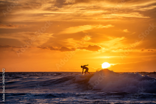 Surfer reitet eine Welle im Sonnenuntergang Teneriffas