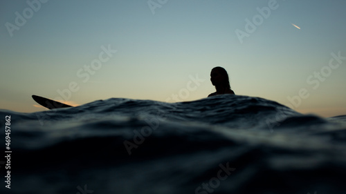 beautiful girl with a surfboard at sunset.