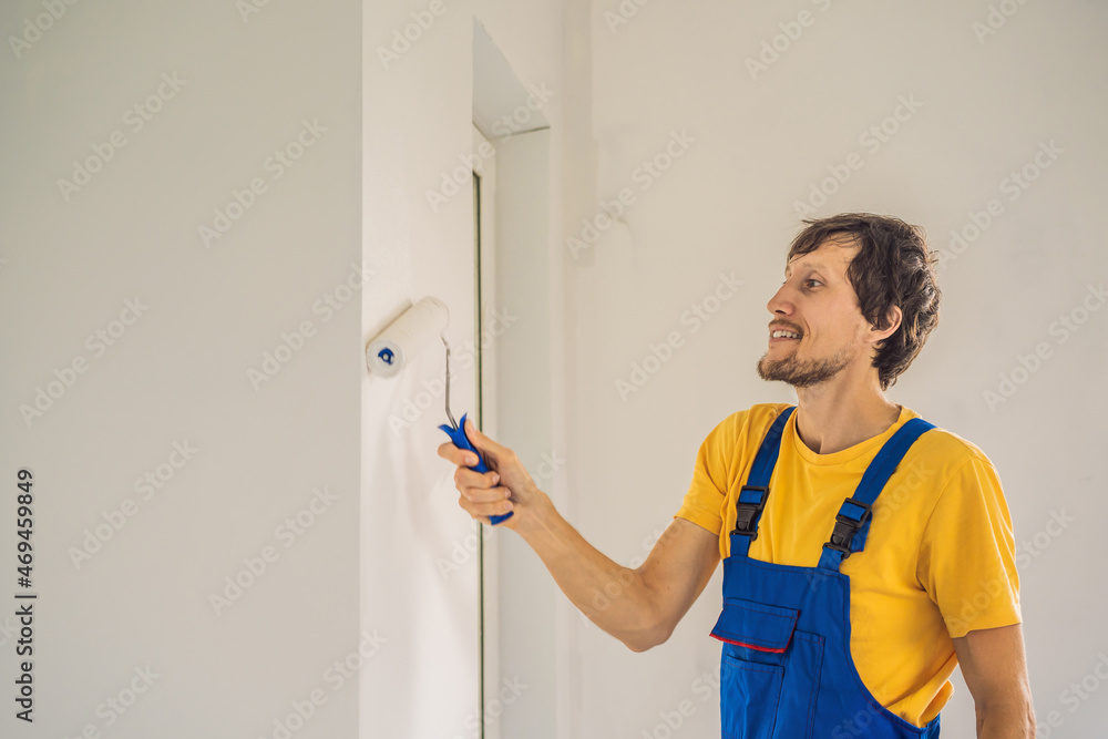 Professional painter worker painting and priming wall with painting roller Professional painter worker painting and priming wall with painting roller