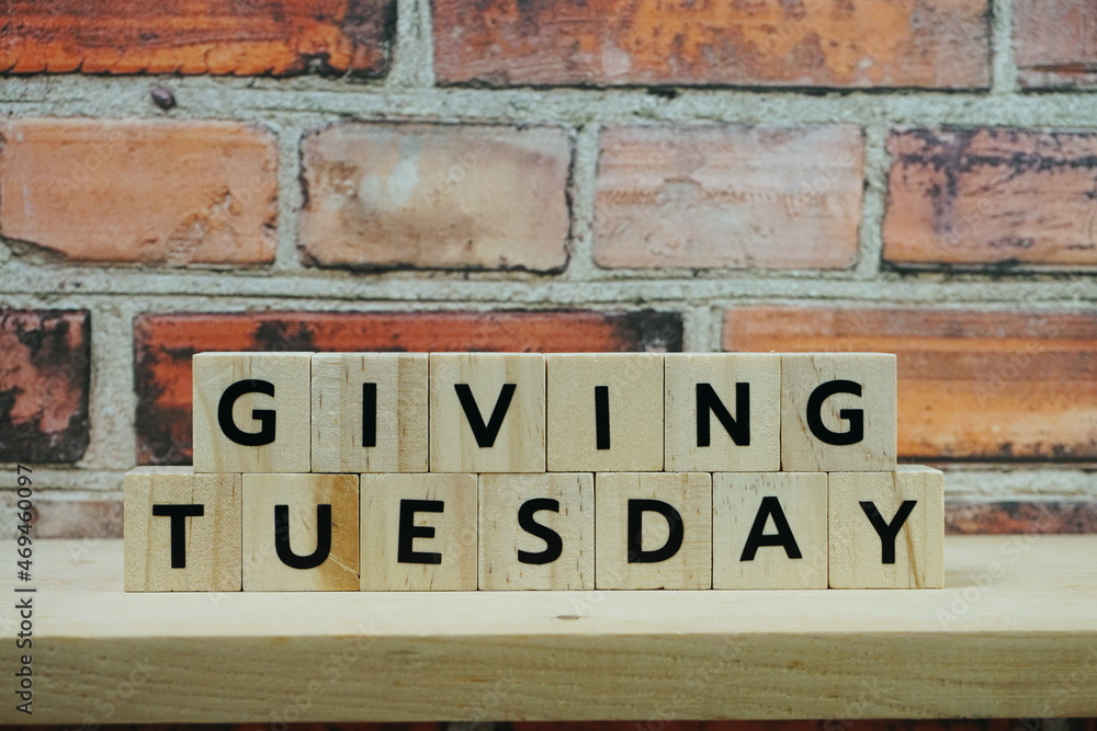 Fototapeta premium Giving Tuesday alphabet letter on wooden shelves background