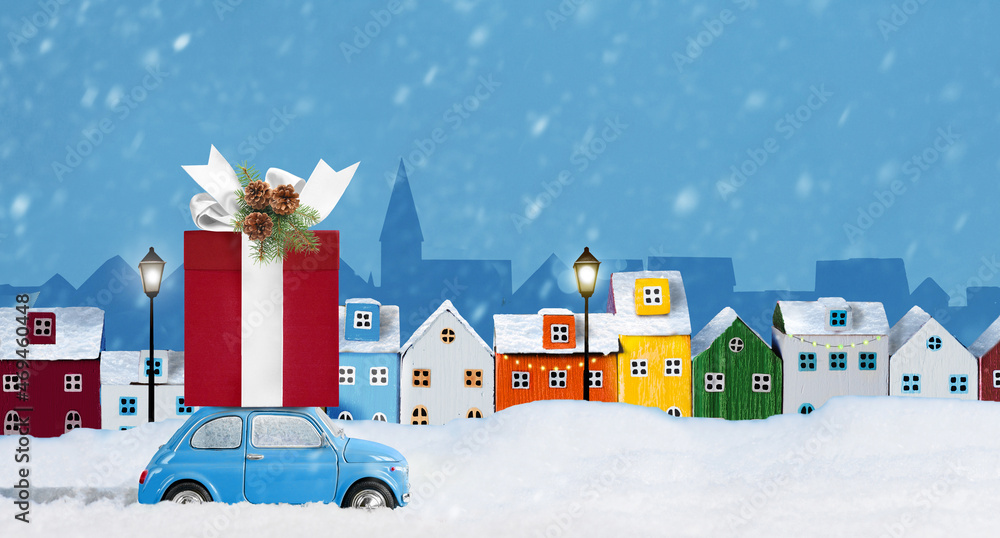 Blue car with christmas gift box on a roof on snow-covered city background