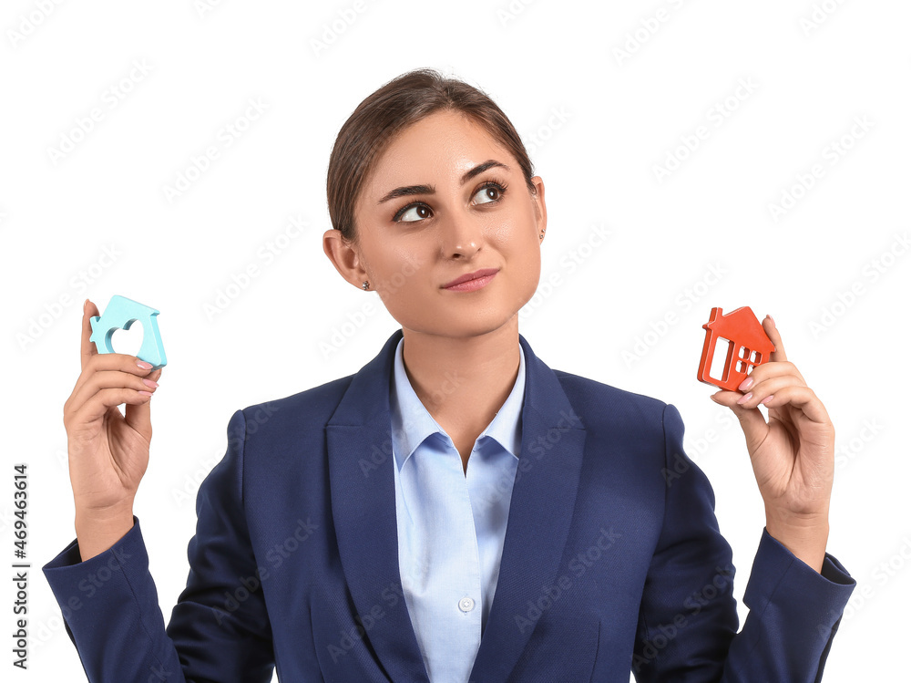 Thoughtful female real estate agent with figures of house on white background Thoughtful female real estate agent with figures of house on white background