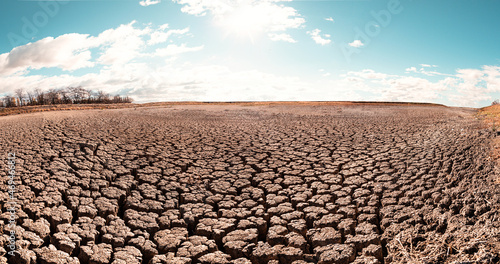 Empty barren field, cracked surface view with copy space. Global warming and climate problem concept for background and design.