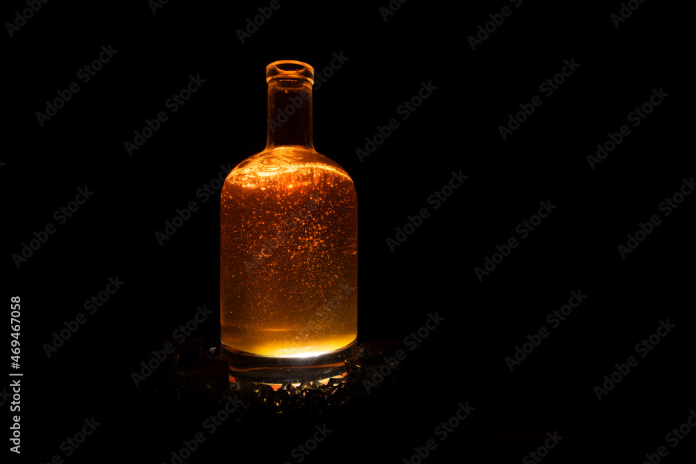 dark brown liquid bottle with refraction and highlights on dark background dark brown liquid bottle with refraction and highlights on dark background