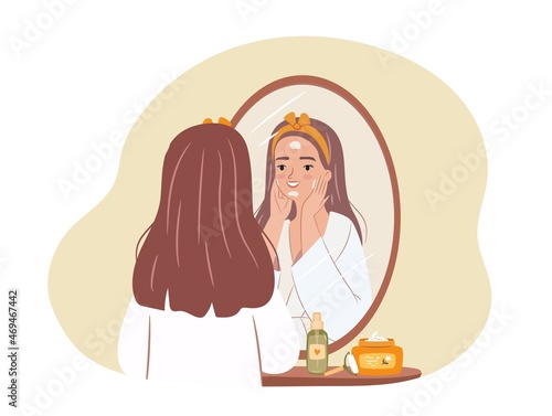 Woman doing beauty routine. Face care concept. Girl applying a mask in front of mirror