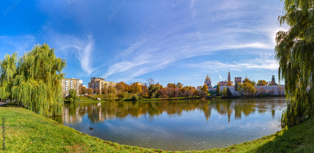 View of the Novodevichy convent (Bogoroditse-Smolensky monastery) and the big Novodevichy pond on a sunny autumn day(panoramic view). Moscow, Russia. UNESCO world heritage site