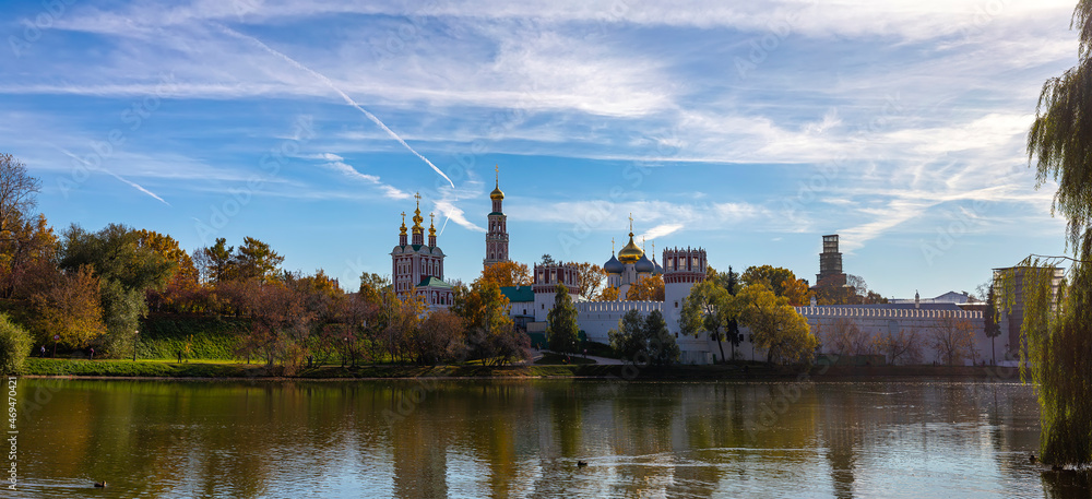 View of the Novodevichy convent (Bogoroditse-Smolensky monastery) and the big Novodevichy pond on a sunny autumn day(panoramic view). Moscow, Russia. UNESCO world heritage site