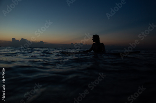 beautiful girl with a surfboard at sunset.