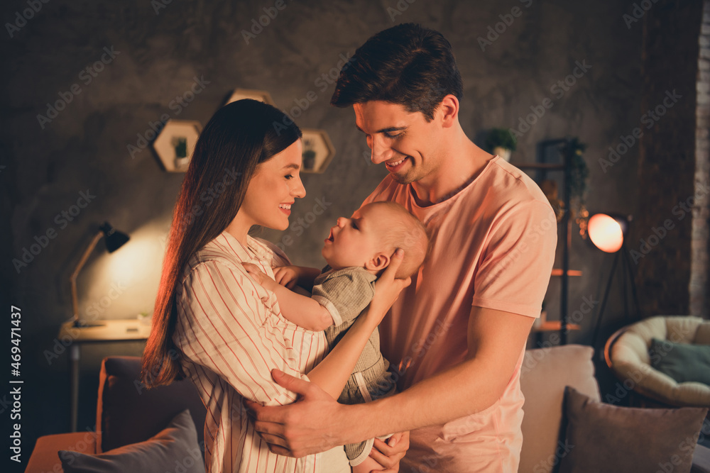 Fototapeta premium Portrait of attractive idyllic cheerful family parenthood cuddling toddler late night at home house flat indoors