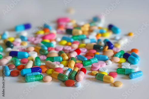 Colorful capsules, pills and tablets on white table, medical treatment