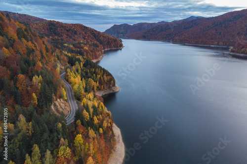 Aerial view of colorful mountain road, at Vidraru Dam - Transfagarasan Highway, Romania, during autumn