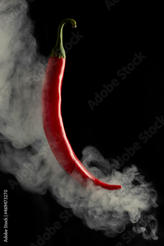 Chili pepper in smoke. On a black background