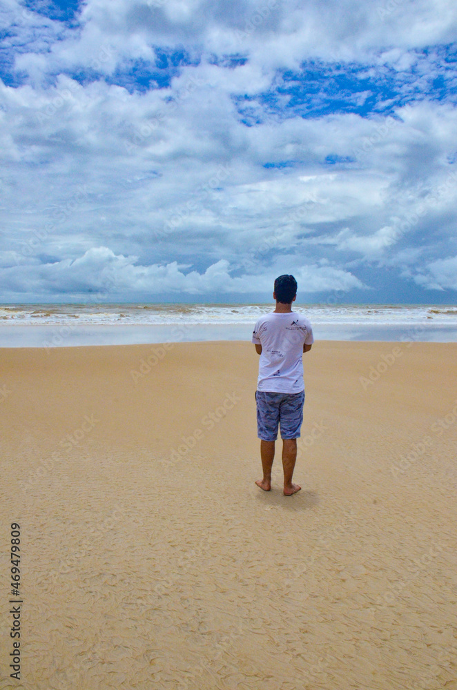 A beautiful view of boy looking the sea in Ilheus beach, Bahia, Brazil.