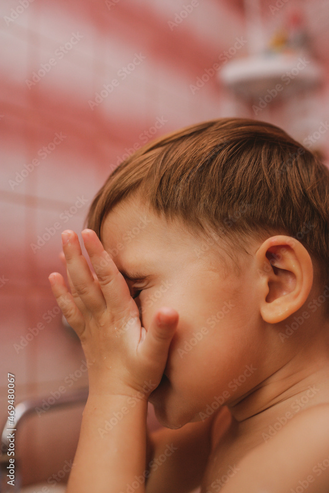 Little boy washes in a bathroom. Little boy washing his face in the bathroom. Going to sleep. Hygiene and a healthy lifestyle Little boy washes in a bathroom. Little boy washing his face in the bathroom. Going to sleep. Hygiene and a healthy lifestyle