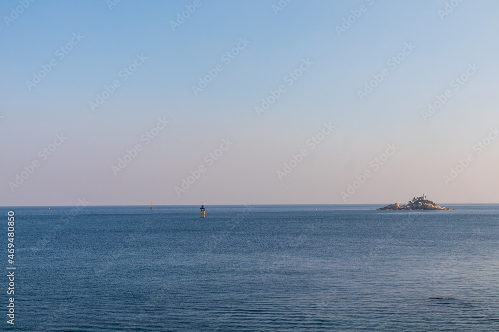 The blue sea with sunset, two lighthouses and a small island. The blue sea with sunset, two lighthouses and a small island.
