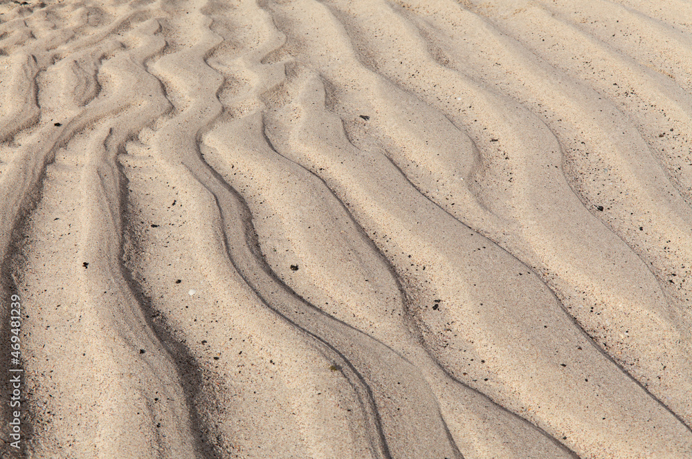 natural sand pattern created by a flow of tide and ripples on the edge of a beach natural sand pattern created by a flow of tide and ripples on the edge of a beach