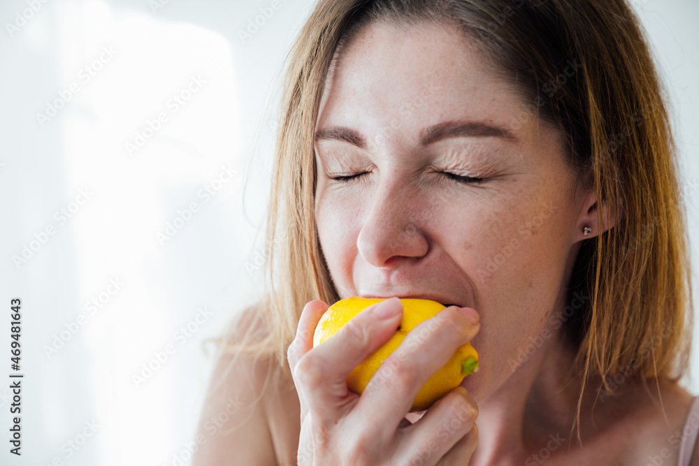 beautiful woman with blond hair eat a yellow sour lemon beautiful woman with blond hair eat a yellow sour lemon