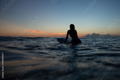 beautiful girl with a surfboard at sunset. © alexzhilkin