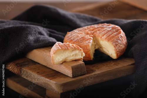 French creamy ripe Epoisses cheese on wooden background