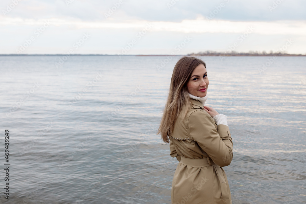 Young caucasian woman walking on the beach in autumn