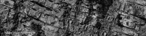 Grungy cragged bumpy pitted cavity stone facade, split layer gap.Ruined cracked shattered worn rough hiking canyon.Old ragged grunge steep marble cliff. Grand vintage crannied damaged impressive gorge
