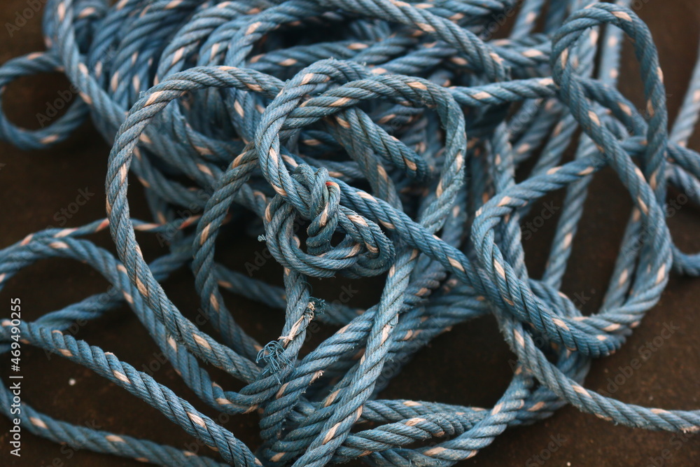 The blue rope that looks tangled has finished being used to tie the one that is placed on the floor