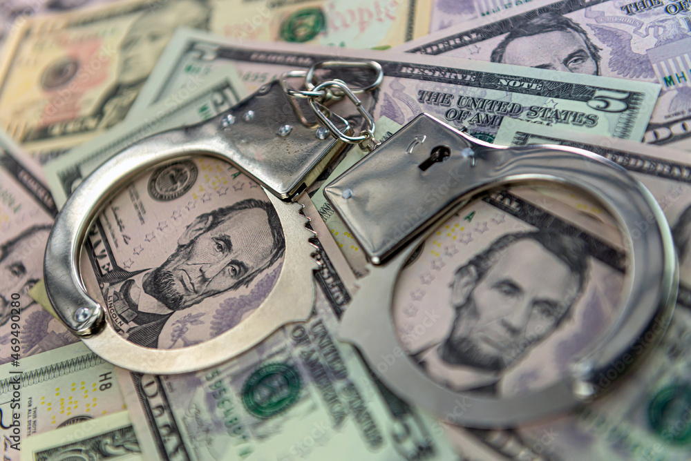 handcuffs on money background, dollar bills, money cash corruption, dirty money, police handcuffs handcuffs on money background, dollar bills, money cash corruption, dirty money, police handcuffs