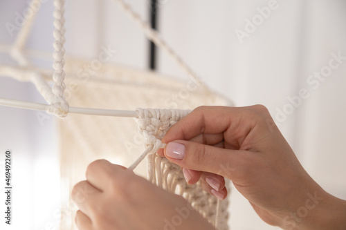 closeup weaving of macrame threads , women's hands