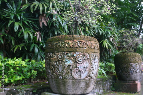 A large flower pot which on the outside contains a Balinese carving motif that adds to the vintage impression where this pot is placed in a Denpasar city park