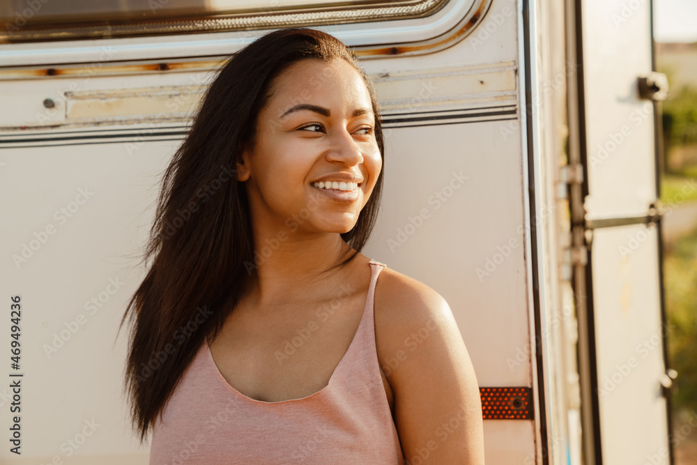 Black young woman with smiling and looking aside by trailer Black young woman with smiling and looking aside by trailer