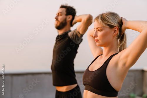 Young man and woman doing exercise while working out together on parking © Drobot Dean